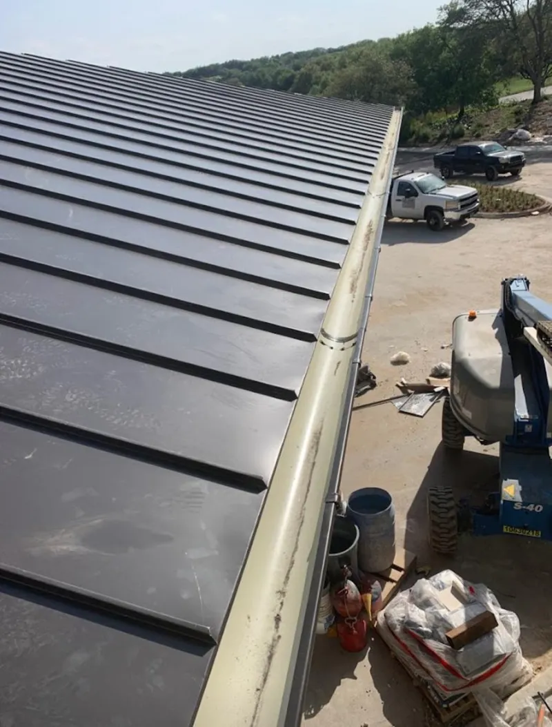 Standing seam panel and gutter detail on a metal roofing jobsite in Anoka